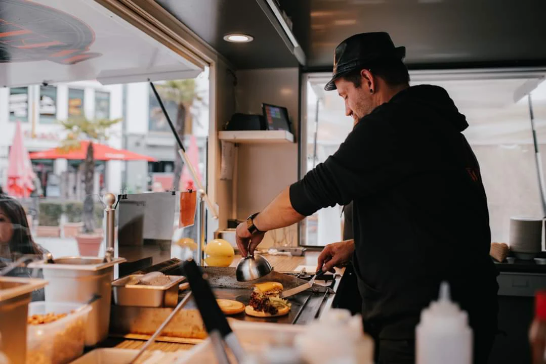 Enrico bereitet frisches Essen im Food on Wheels Truck zu